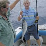 Capt. John Quattlebaum (left) helps David Ellison of West Virginia gaff the angler’s first king mackerel.