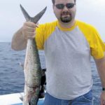 Joshua Ellison displays a king mackerel that once had been in a net.