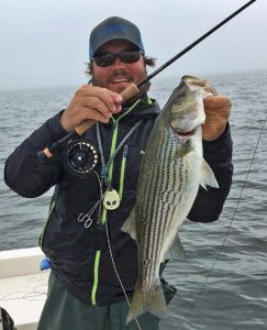 Guide Richard Andrews shows off a striper from a coastal river that fell for a fly.