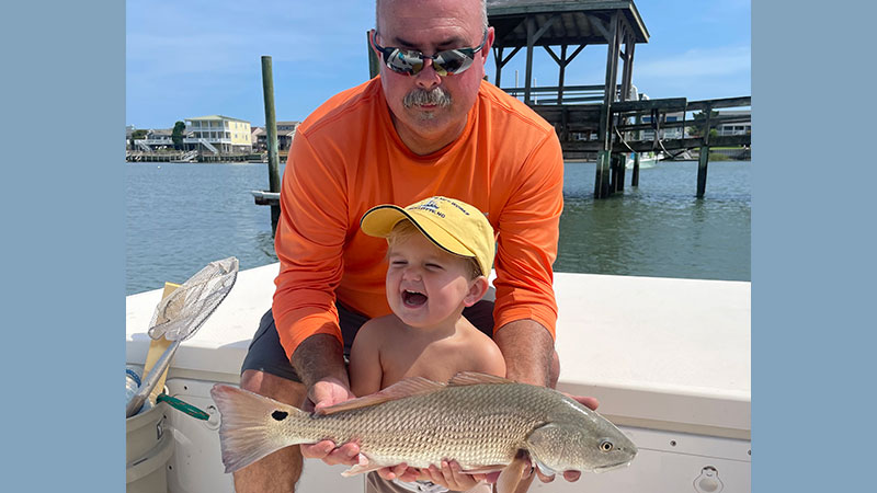 Stetson Hauser and his grandpa Shawn Simpson, with a keeper red drum caught on live mullet in Tubbs Inlet.
